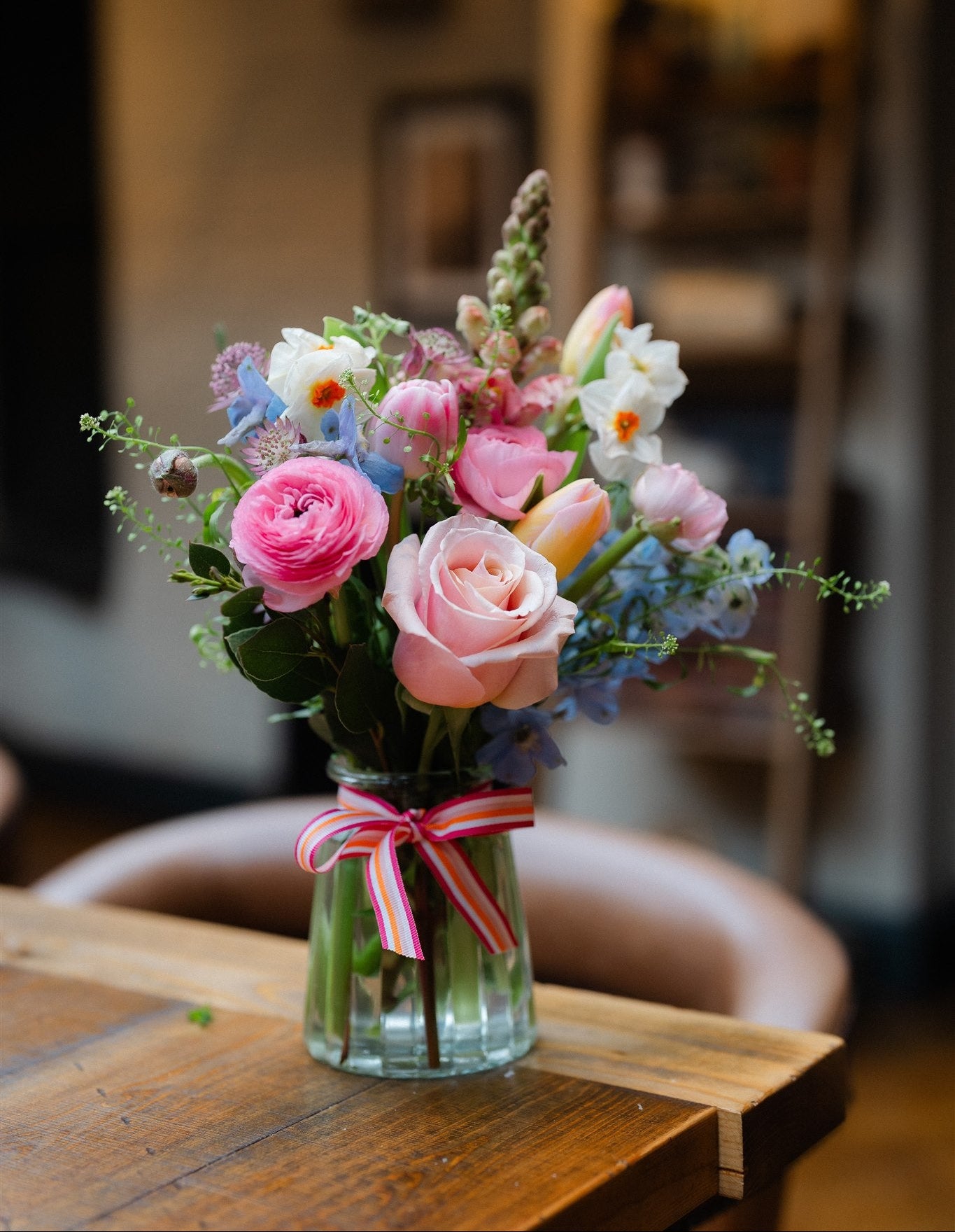Seasonal flowers arranged in a reusable keepsake jar with natural garden-style flowers and foliage.