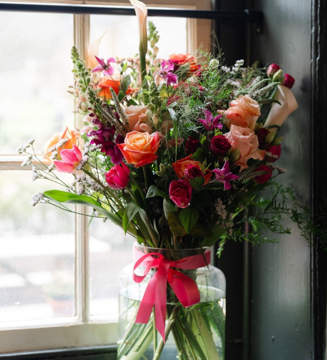 Summer Showstopper Vase with premium roses arranged in a glass apothecary vase