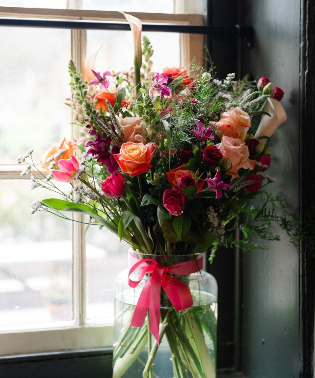 Summer Showstopper Vase with premium roses arranged in a glass apothecary vase