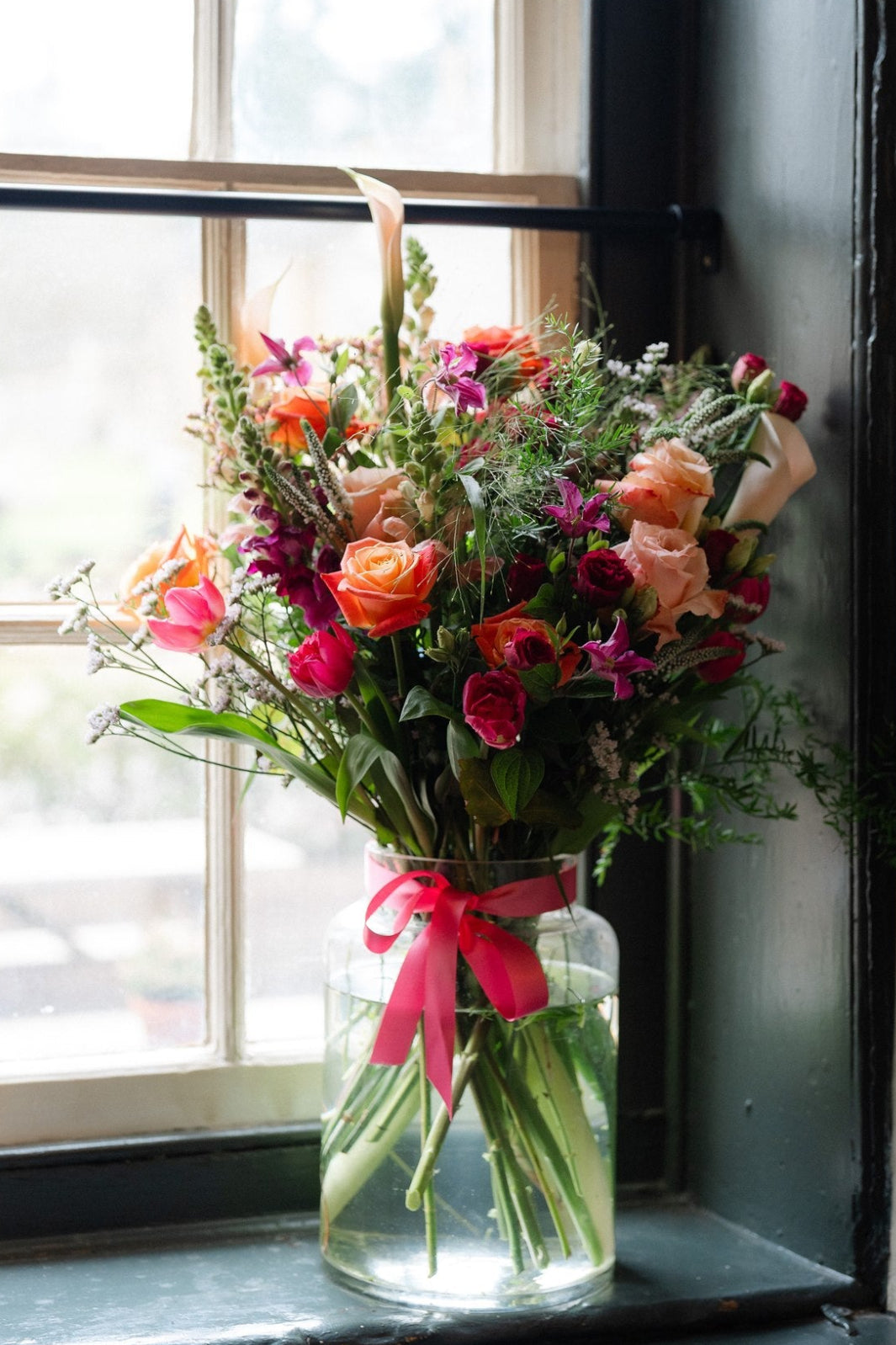 Summer Showstopper Vase with premium roses arranged in a glass apothecary vase