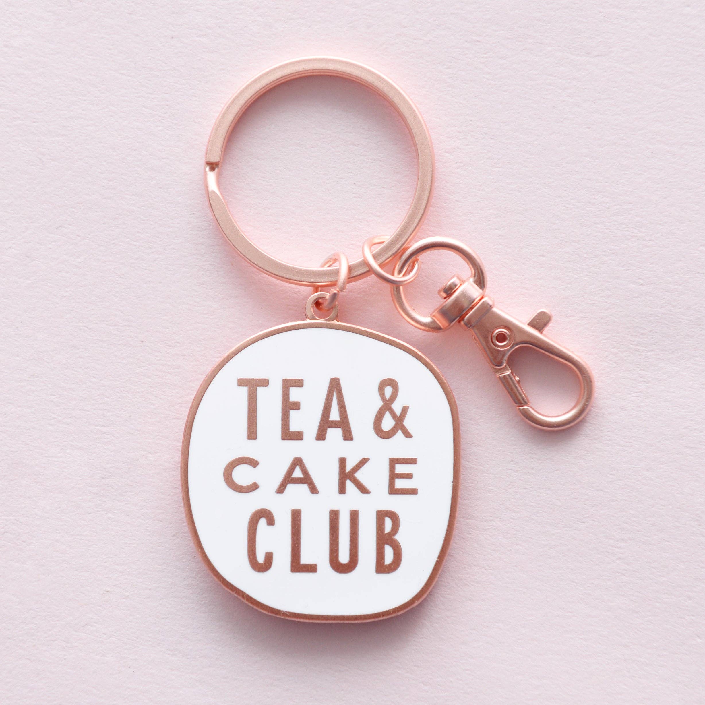 Keychain with 'Tea & Cake Club' text on a light pink background