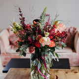 The Christmas Showstopper luxury Christmas flower vase arrangement featuring abundant seasonal flowers and festive winter foliage, handcrafted by Mad Lilies florists.