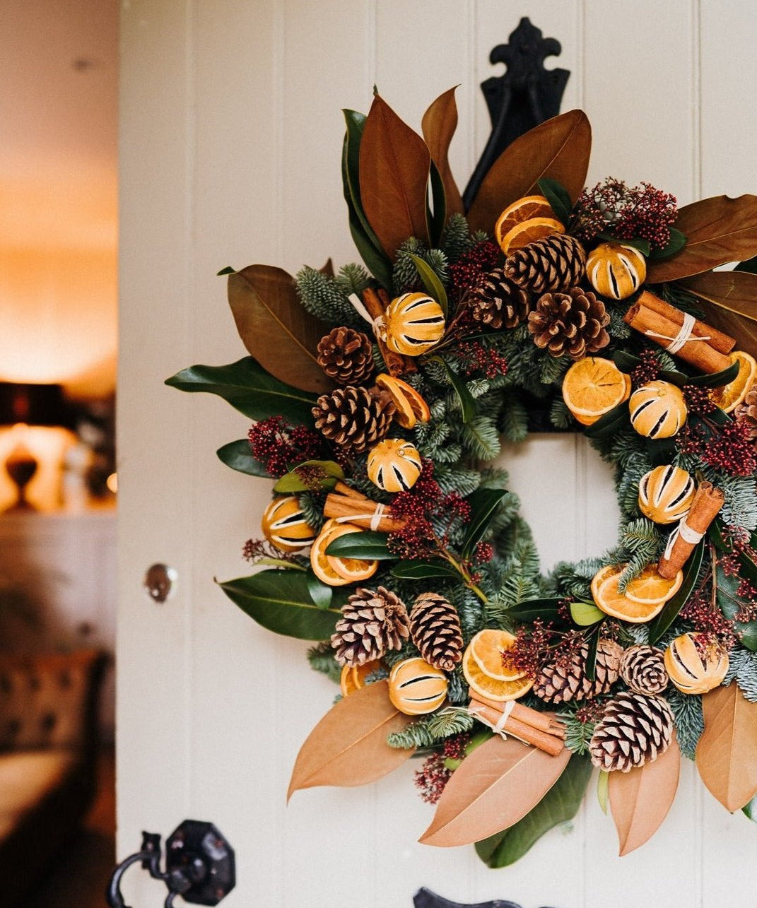 Alt text: The Clementine luxury Christmas door wreath with magnolia, spruce, oranges and velvet ribbon