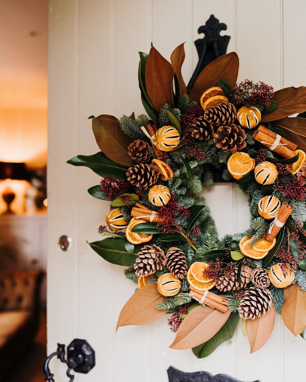 Alt text: The Clementine luxury Christmas door wreath with magnolia, spruce, oranges and velvet ribbon