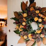 Alt text: The Clementine luxury Christmas door wreath with magnolia, spruce, oranges and velvet ribbon