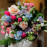 The Daydream bouquet by Mad Lilies featuring premium roses and seasonal flowers in blush pink, powder blue and white, hand-tied in our signature naturally abundant style.