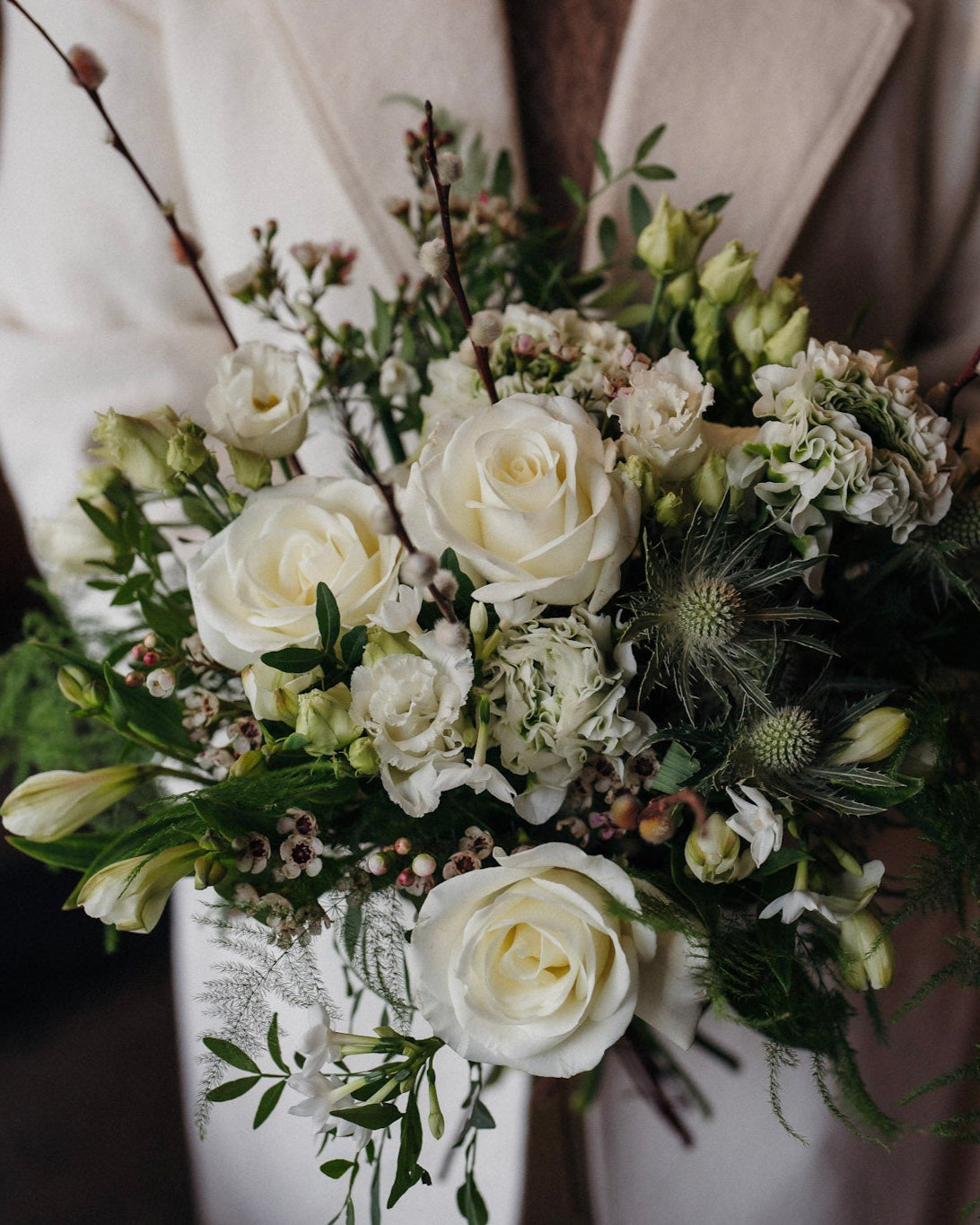 The December white winter flower bouquet with White Tibet roses, lisianthus, waxflower and pussy willow.