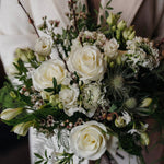The December white winter flower bouquet with White Tibet roses, lisianthus, waxflower and pussy willow.