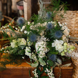 The Highland Mist luxury winter bouquet featuring elegant white Tibet roses, blue-grey thistles, lisianthus, waxflower and pussy willow, hand-tied by Mad Lilies.