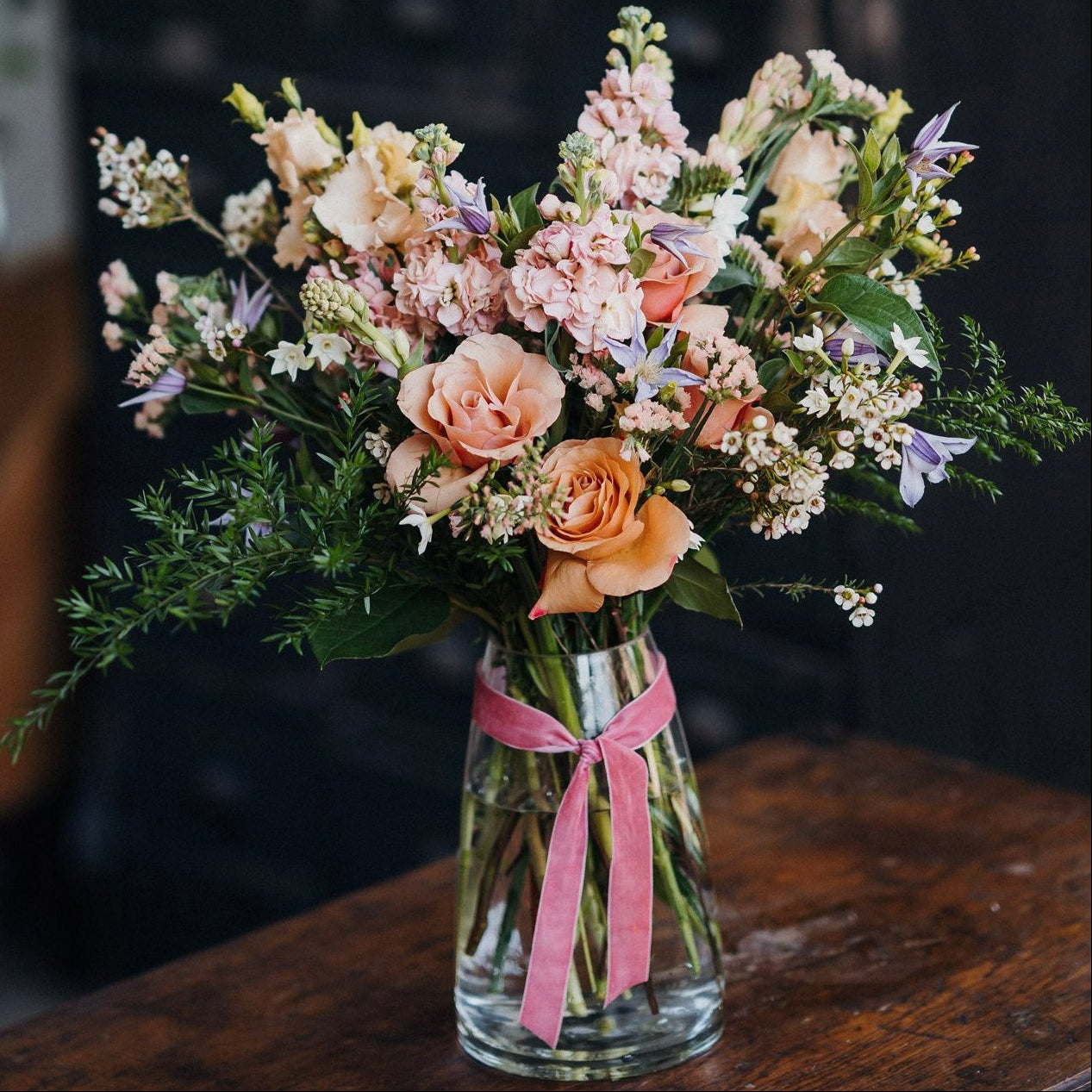 Seasonal flower arrangement in a vase featuring fresh flowers and foliage in a natural garden-inspired style.