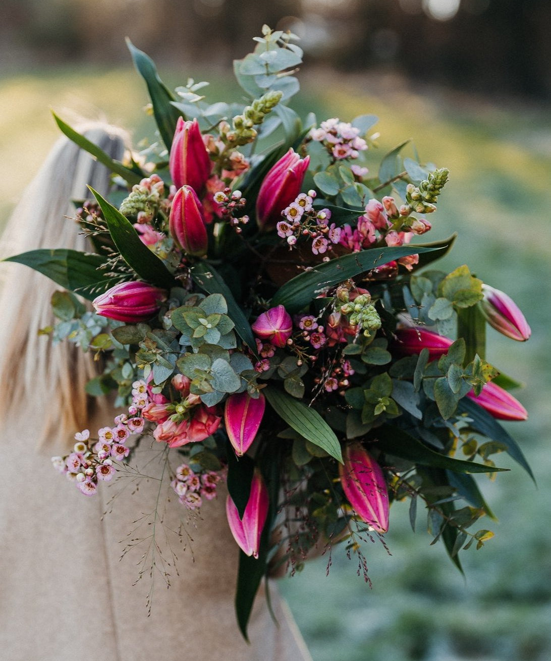 Fragrant pink Oriental lily bouquet with seasonal flowers and eucalyptus foliage in a natural garden-inspired style.