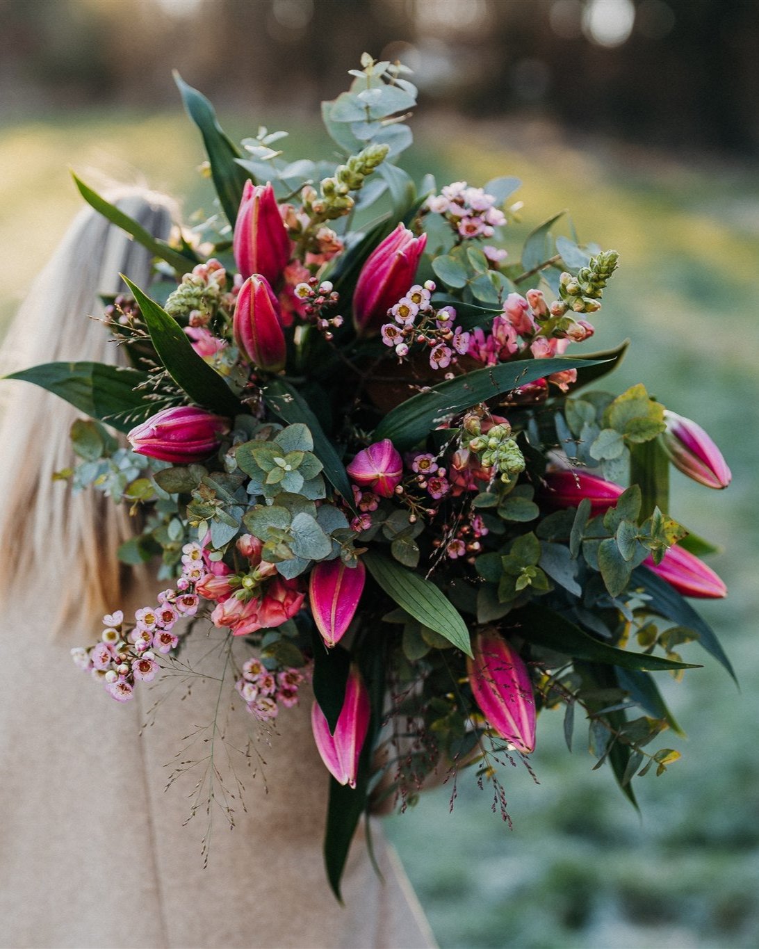 Fragrant pink Oriental lily bouquet with seasonal flowers and eucalyptus foliage in a natural garden-inspired style.