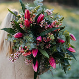 Fragrant pink Oriental lily bouquet with seasonal flowers and eucalyptus foliage in a natural garden-inspired style.