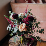 The Velvet Kiss luxury Christmas flower posy with Mother of Pearl roses, damson blooms, mulberry astilbe, astrantia, blush waxflower, white thistles and eucalyptus.