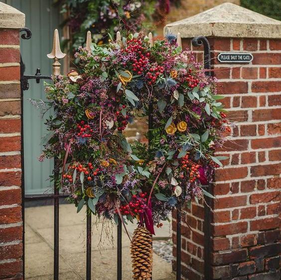 Discover The Velvet Waltz, our luxurious oversized Christmas door wreath, handmade with fragrant winter foliage, berries, dried fruits and velvet ribbon.