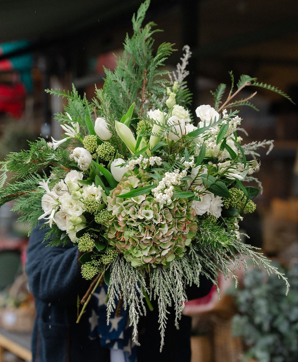 The Winter Waltz, a luxury white Christmas bouquet with amaryllis, matcha hydrangea, white roses and festive pine. Hand-tied by Mad Lilies in Surrey.