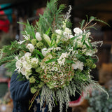 The Winter Waltz, a luxury white Christmas bouquet with amaryllis, matcha hydrangea, white roses and festive pine. Hand-tied by Mad Lilies in Surrey.