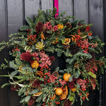 The Winterberry luxury fresh Christmas door wreath with pine, eucalyptus, red skimmia, rosehips, pink pepperberries, pinecones, dried oranges and limes.