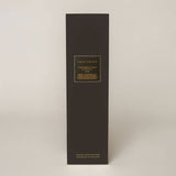 True Grace Portobello Oud Reed Diffuser in a smoked glass bottle with black rattan reeds, luxury home fragrance handcrafted in Wiltshire.