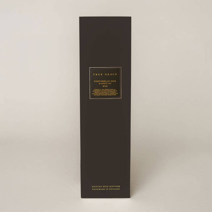 True Grace Portobello Oud Reed Diffuser in a smoked glass bottle with black rattan reeds, luxury home fragrance handcrafted in Wiltshire.