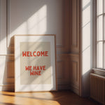 Playful red and cream typography wall art featuring the phrase ‘Welcome We Have Wine’. Premium giclée kitchen print perfect for dining spaces and gallery walls.