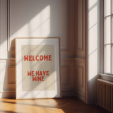 Playful red and cream typography wall art featuring the phrase ‘Welcome We Have Wine’. Premium giclée kitchen print perfect for dining spaces and gallery walls.