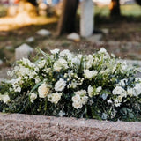 Natural garden-style casket spray funeral flowers featuring seasonal blooms and foliage, handcrafted by Mad Lilies florists in Banstead, Surrey.