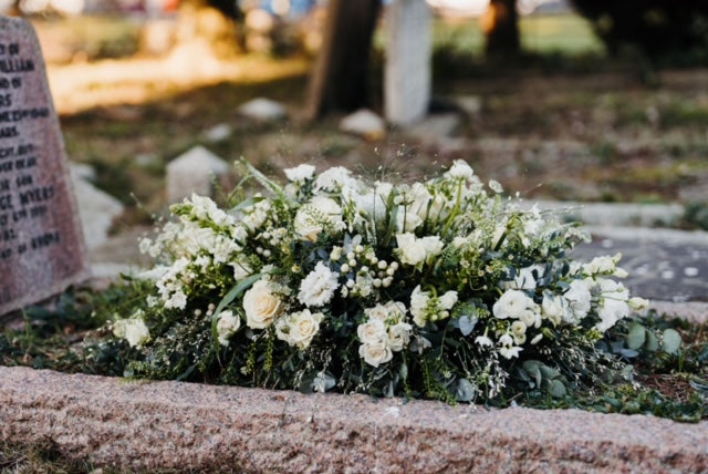 Natural garden-style casket spray funeral flowers featuring seasonal blooms and foliage, handcrafted by Mad Lilies florists in Banstead, Surrey.