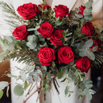 The Winter Cherry Roses luxury bouquet of long-stemmed Red Explorer roses with fragrant green eucalyptus.