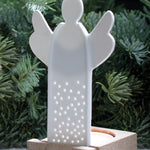 A white porcelain angel tealight holder with decorative holes