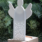 A white porcelain angel tealight holder with decorative holes