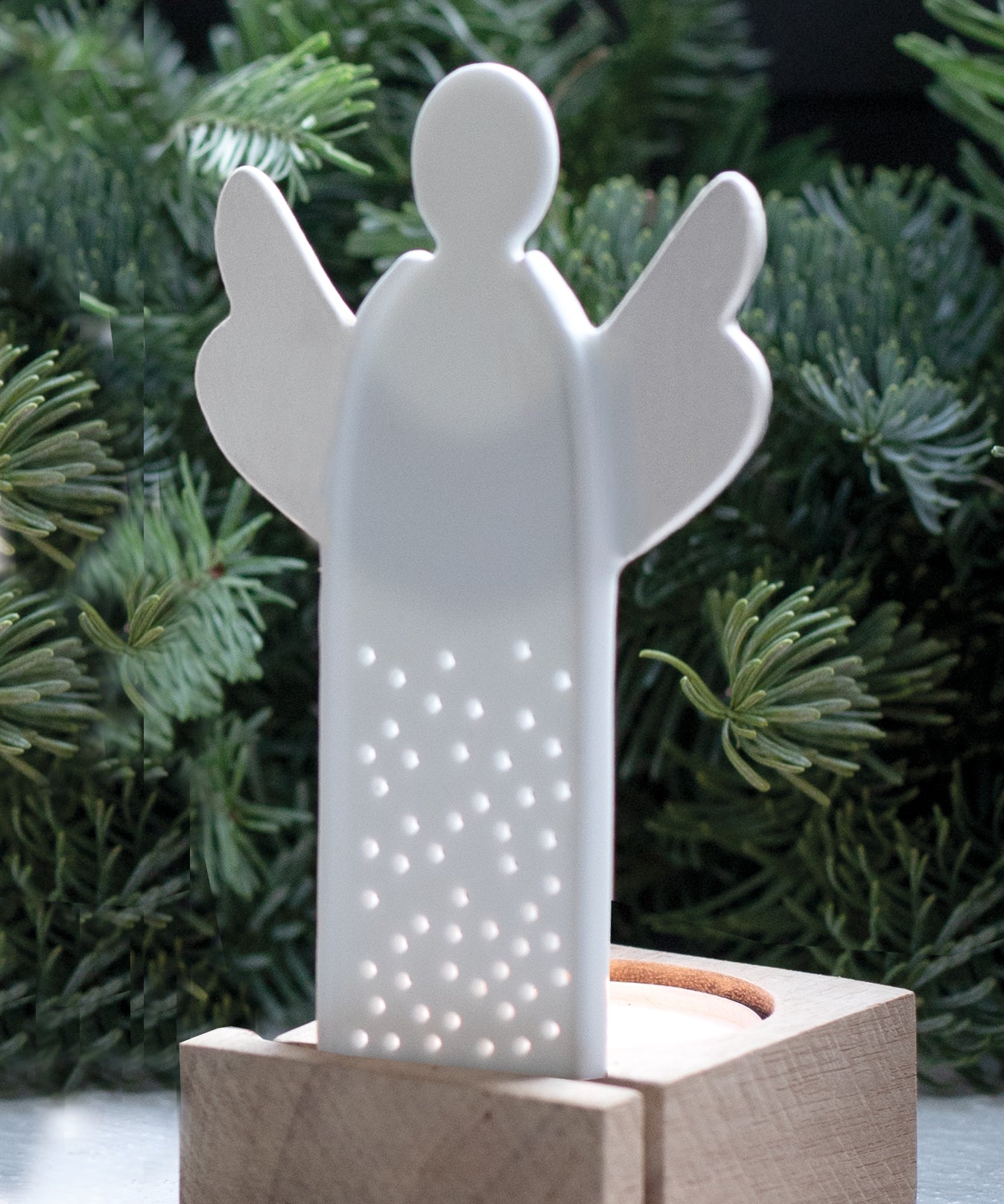 A white porcelain angel tealight holder with decorative holes