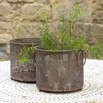 Two vintage metal lanterns with a perforated design 