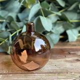 Amber bauble-shaped glass bud vase for a single flower stem