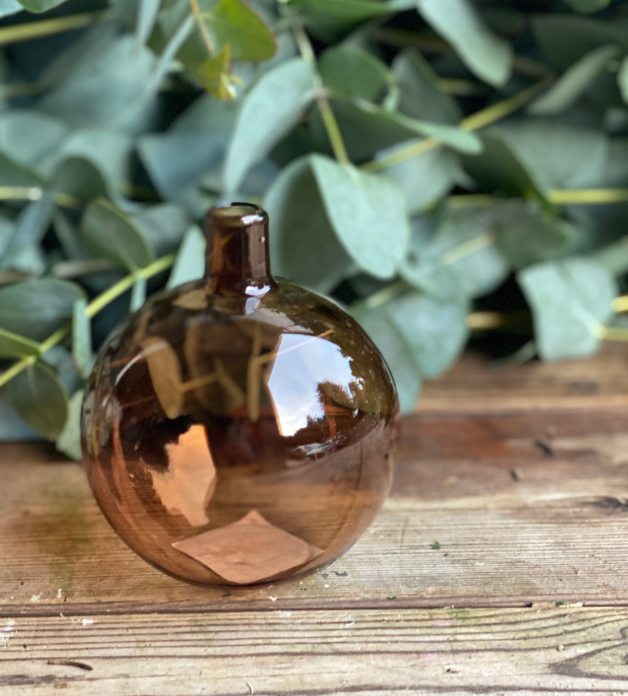 Amber bauble-shaped glass bud vase for a single flower stem