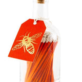 Archivist long orange safety matches in a decorative glass bottle with cork stopper and letterpress bee label for lighting candles and fireplaces.