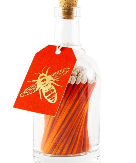 Archivist long orange safety matches in a decorative glass bottle with cork stopper and letterpress bee label for lighting candles and fireplaces.