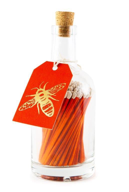 Archivist long orange safety matches in a decorative glass bottle with cork stopper and letterpress bee label for lighting candles and fireplaces.