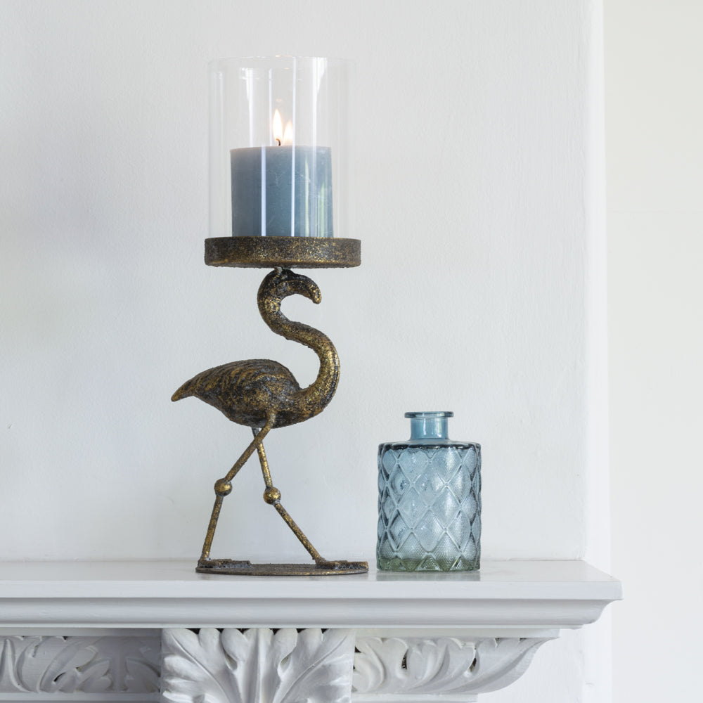 Playful gold flamingo lantern with an aged finish and elegant design. A decorative statement lantern perfect for candlelight, shelves and eclectic interiors.