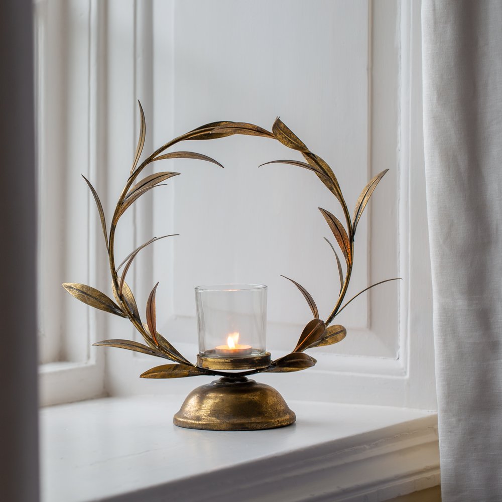 Elegant gold laurel leaf candle holder with a distressed finish. A striking decorative centrepiece for dinner parties, seasonal tables and ambient candlelight.