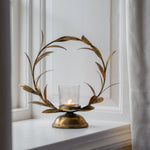 Elegant gold laurel leaf candle holder with a distressed finish. A striking decorative centrepiece for dinner parties, seasonal tables and ambient candlelight.