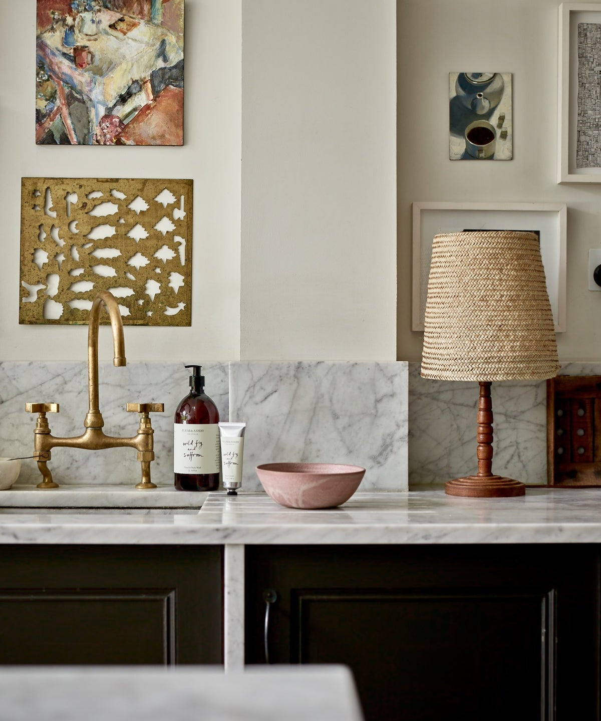 1 Litre bottle of Plum & Ashby Wild Fig & Saffron Hand & Body Wash on a kitchen countertop with a marble backdrop and a gold-patterned napkin holder in the background.