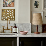 1 Litre bottle of Plum & Ashby Wild Fig & Saffron Hand & Body Wash on a kitchen countertop with a marble backdrop and a gold-patterned napkin holder in the background.