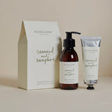 A set of Plum & Ashby seaweed and samphire handwash and hand cream products, with a bottle of hand wash and a tube of hand cream in front of a neutral background, packaged in a beige box with the product names and ingredients listed.