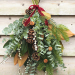The Nordic Welcome fresh Christmas door swag with blue spruce, magnolia, eucalyptus, pinecones and Marsala red velvet ribbon